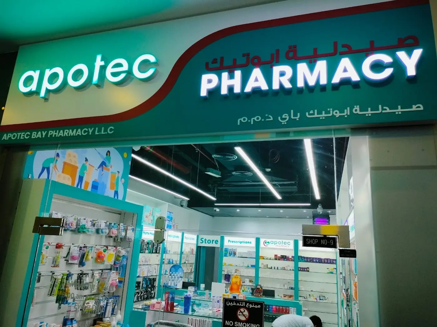 Apotec Bay Pharmacy sign above the glass entrance with Prescriptions lettering